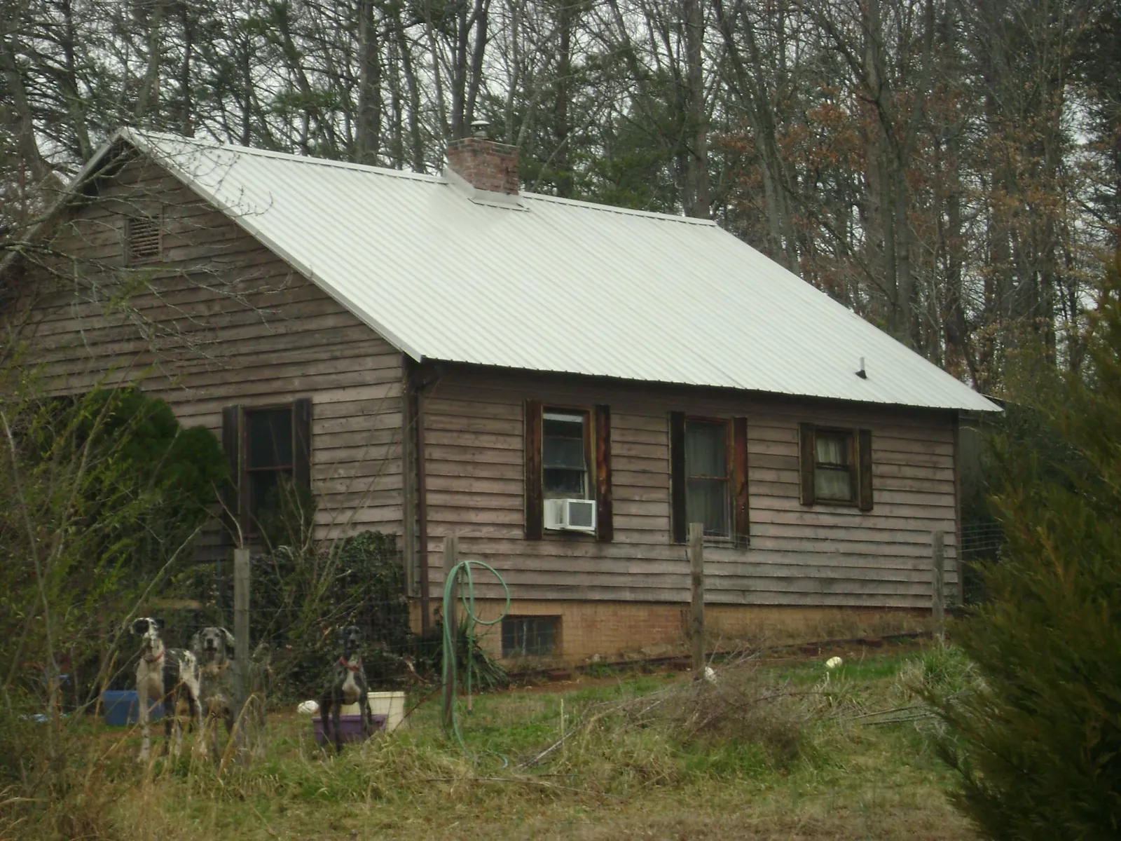 White metal roof on an old wood sided farmhouse, from a Metal Roof Installation job in Bishopville
